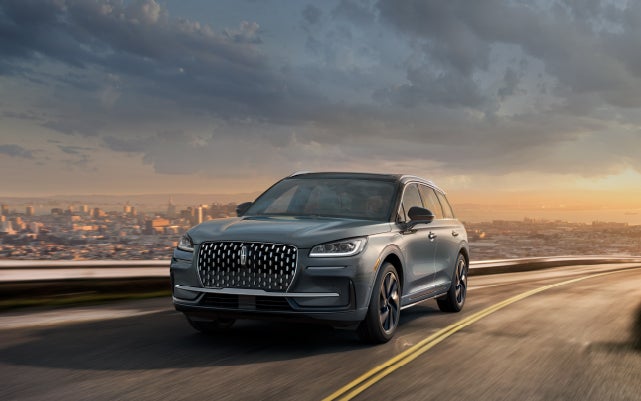 A 2024 Lincoln Corsair® Grand Touring SUV is being driven on a hillside road.